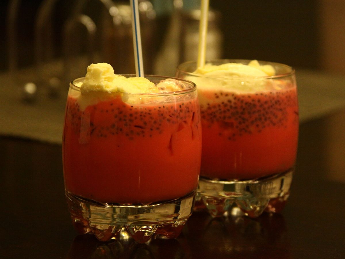 Two glasses of rose falooda topped with ice cream