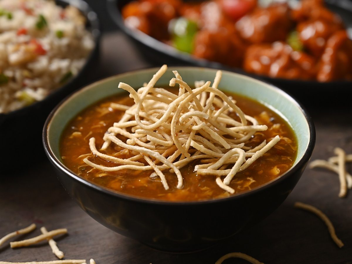 A bowl of manchow soup topped with crispy fried noodles